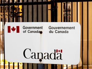 Un panneau générique bilingue anglais et français du gouvernement du Canada sur une clôture de la colline du Parlement à Ottawa.